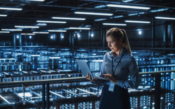 Person on a laptop in a large data centre